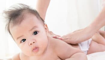 Physician gently massaging a baby’s back