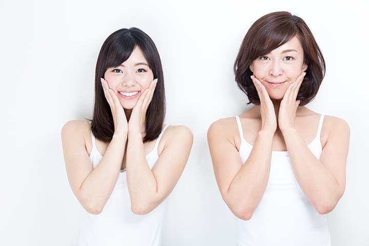 Young daughter and mother touching their cheeks and smiling