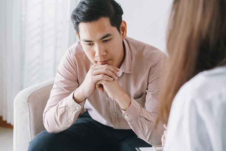 A male patient deep in thought while listening to a doctor