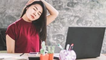 Woman holds breast with a facial expression showing pain