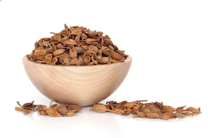 Dried golden bell in a wooden bowl with some spilling outside the bowl