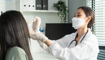 Doctor using a COVID-19 rapid antigen test to do a quick swab on a patient