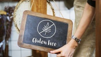 Man holding up a blackboard that says ‘Gluten Free’