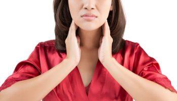 Woman touches the sides of her neck with both hands