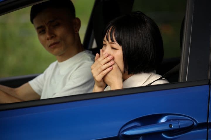 Woman in car experiencing motion sickness 