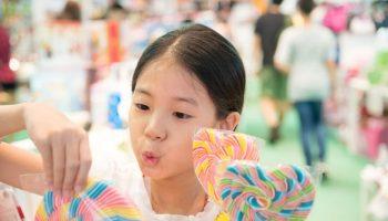 A young girl happily picking out colourful lollipops