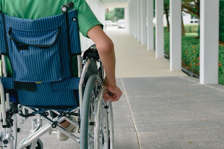 Person on a wheelchair wheeling by himself