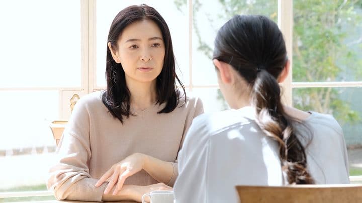 A middle-aged woman sitting opposite her daughter. 