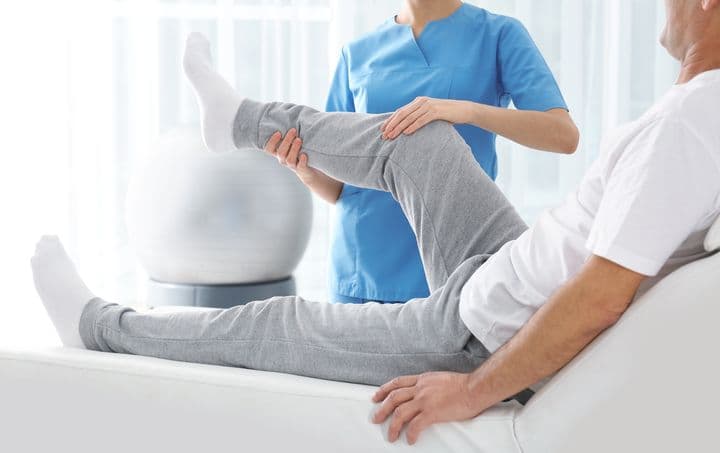 Physiotherapist working on a patient in bed