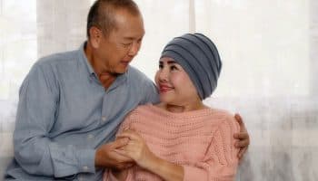 Elderly Asian couple encouraging each other as the wife is on cancer treatment.