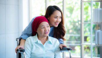 Asian daughter with mother on wheelchair.