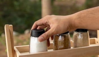 Man taking a bottle of monosodium glutamate from a wooden shelf