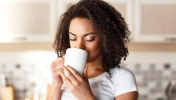 Nice girl drinking tea out of a white mug