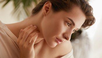 A beautiful woman touching her neck and face checking for stress rash