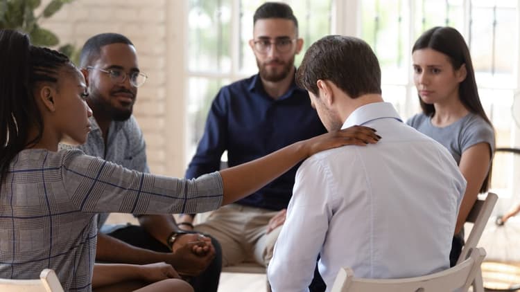 A sad young man attending group therapy 