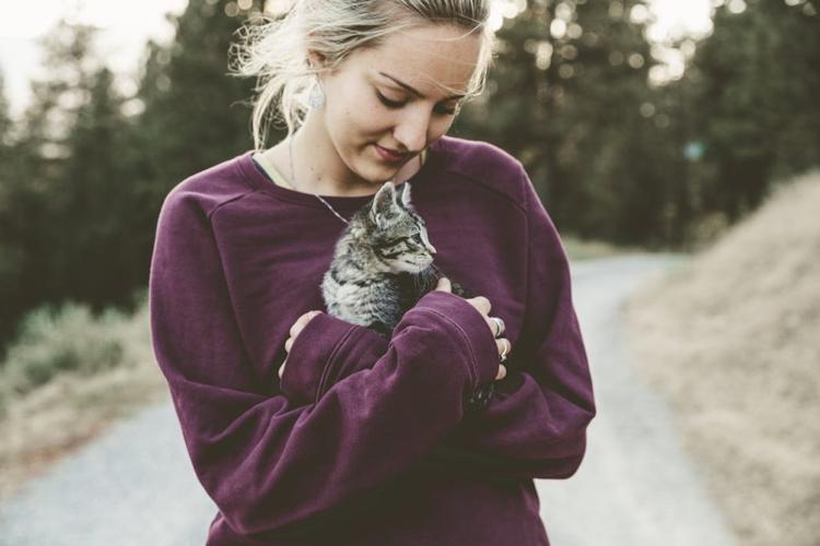 A woman experiencing pet therapy with a cat to alleviate anxiety and depression.