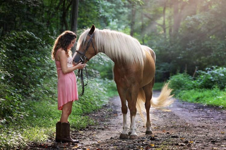 A woman petting a brown horse.