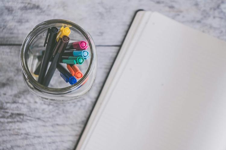 A notebook and colorful markers.